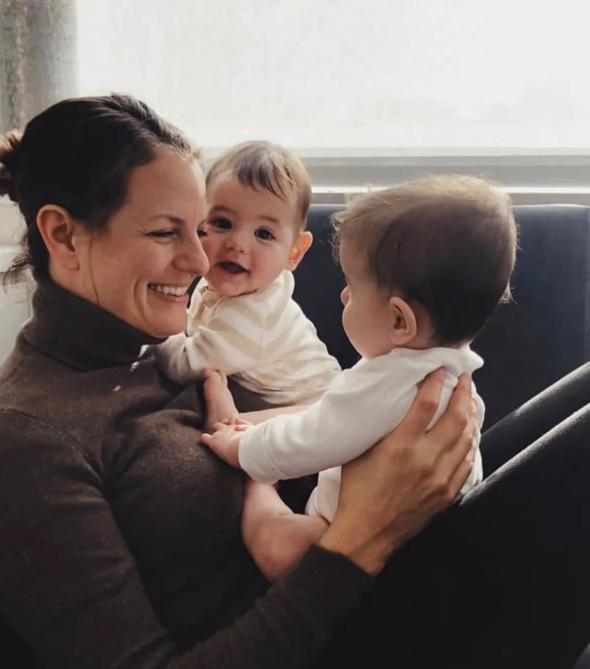 Image of Jenny Best smiling with two babies.